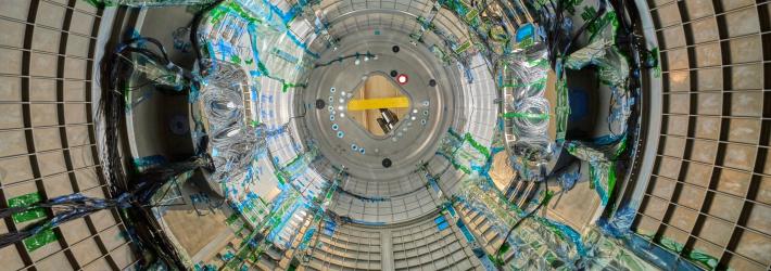 As we look through a circular piece of Gateway, a space station that will be in lunar orbit, there are blue wires snaking through. The wires are covered in clear plastic in some places and held onto the walls by green tape in others.