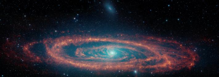 This image of the Andromeda galaxy uses data from NASA’s retired Spitzer Space Telescope. Multiple wavelengths are shown, revealing stars (in blue and cyan), dust (red), and areas of star formation. Dust swirls around like water going down a drain, as the black hole at the heart of the Andromeda consumes it.
